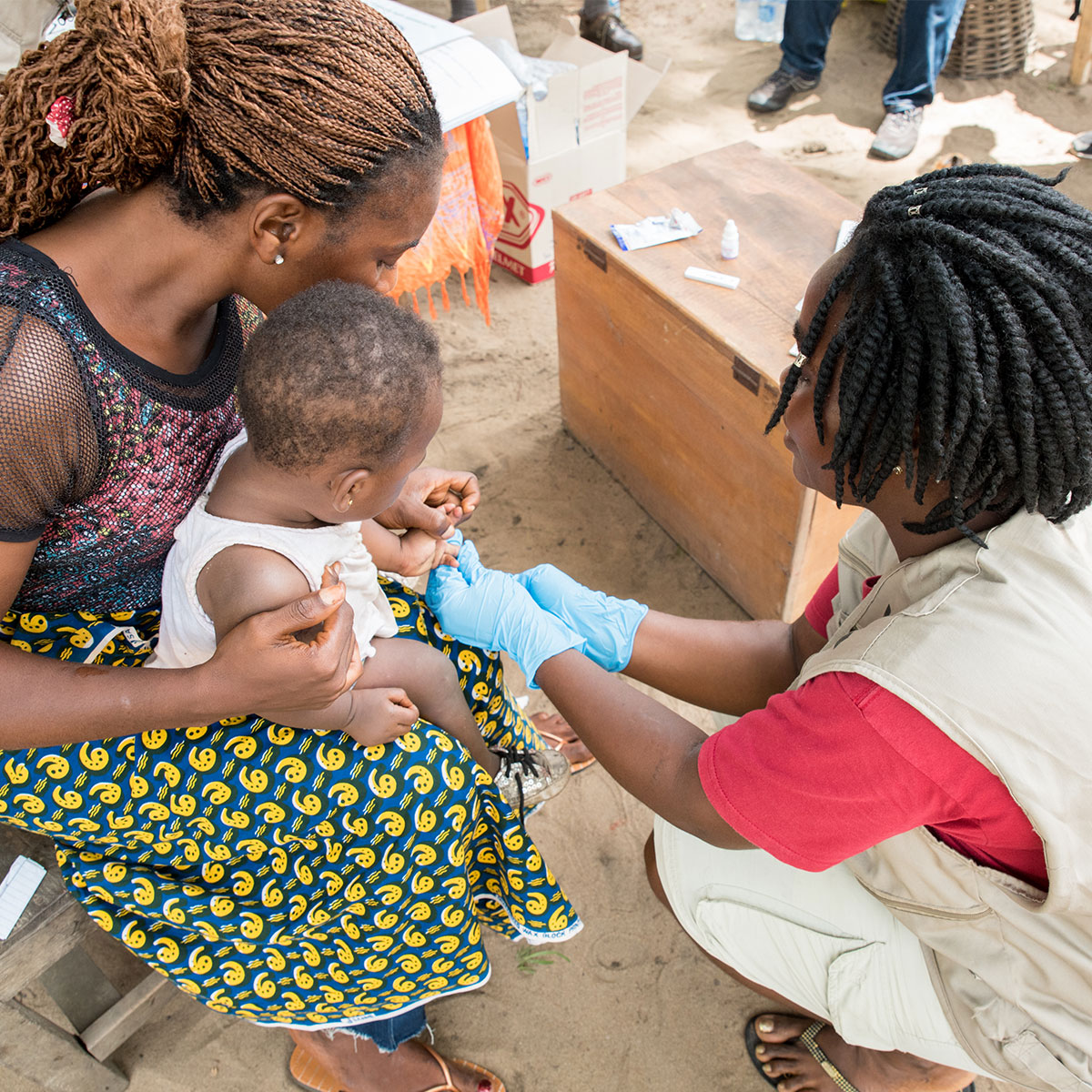 Nurse providing medical assistance to infant in rural environment