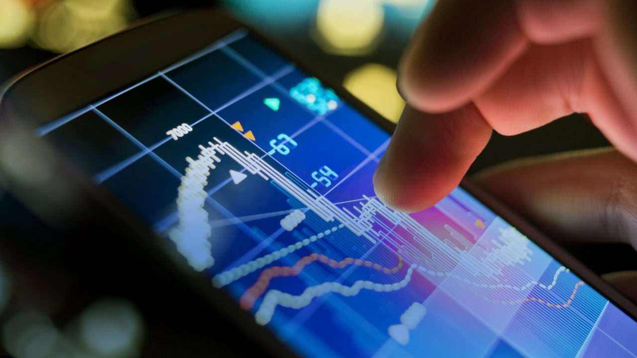 A businessman using a mobile phone to check stock market data